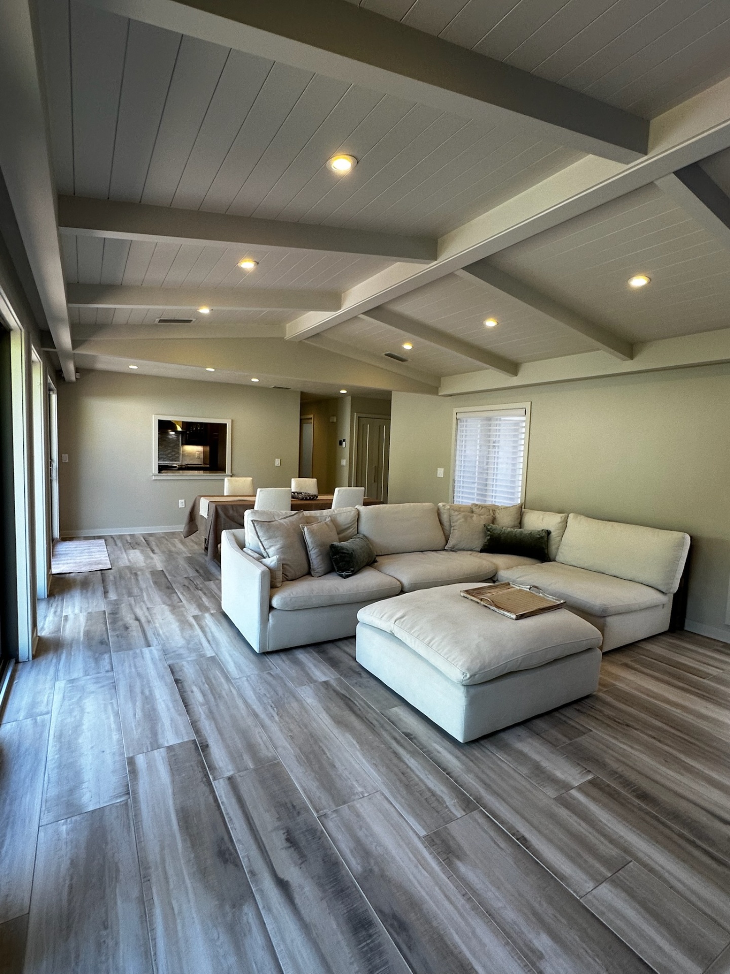 Great room with vaulted beamed ceiling and linen sectional